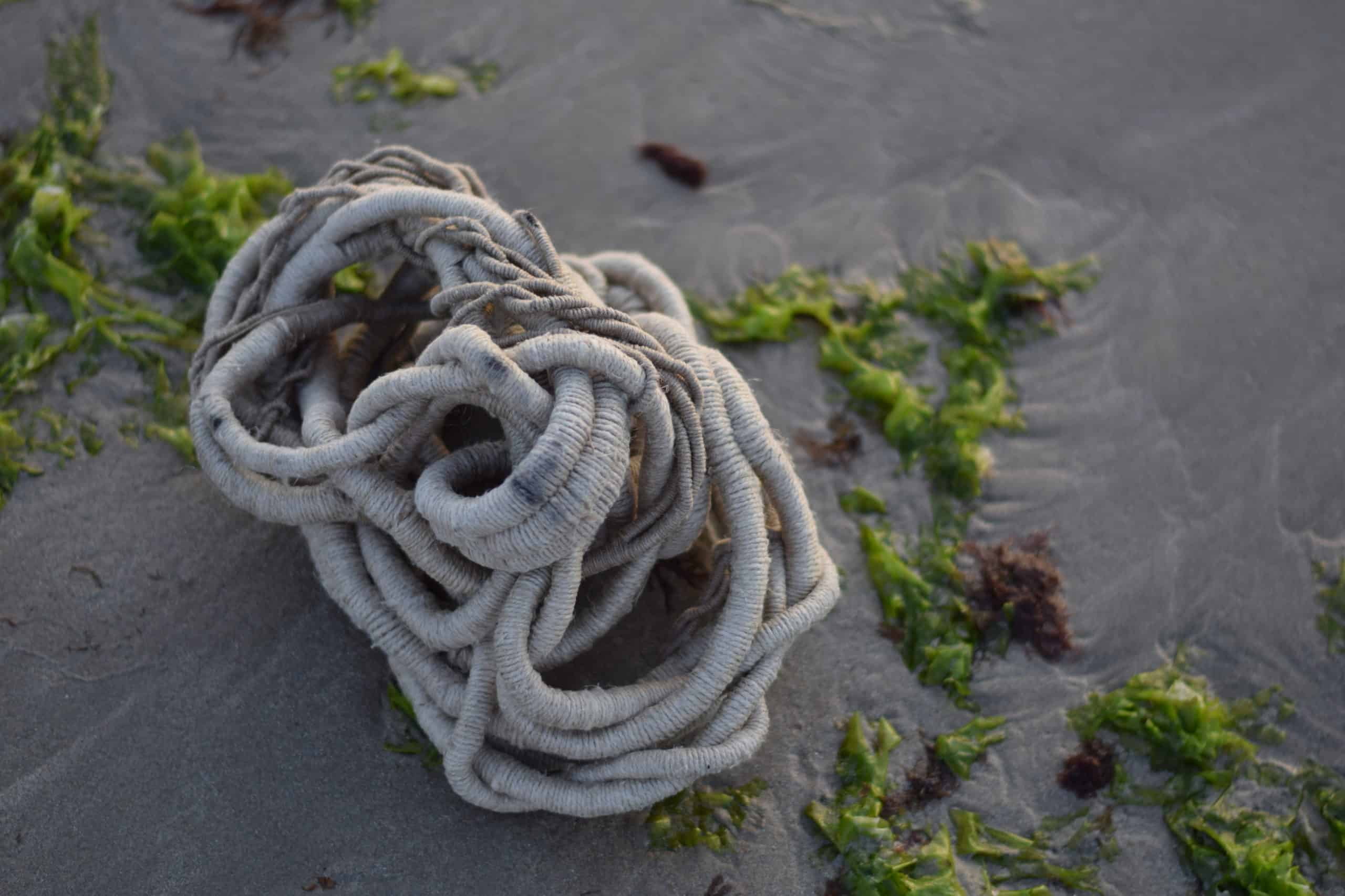 undyed linen sculpture on wet sand and sea weed by artist Aude Franjon