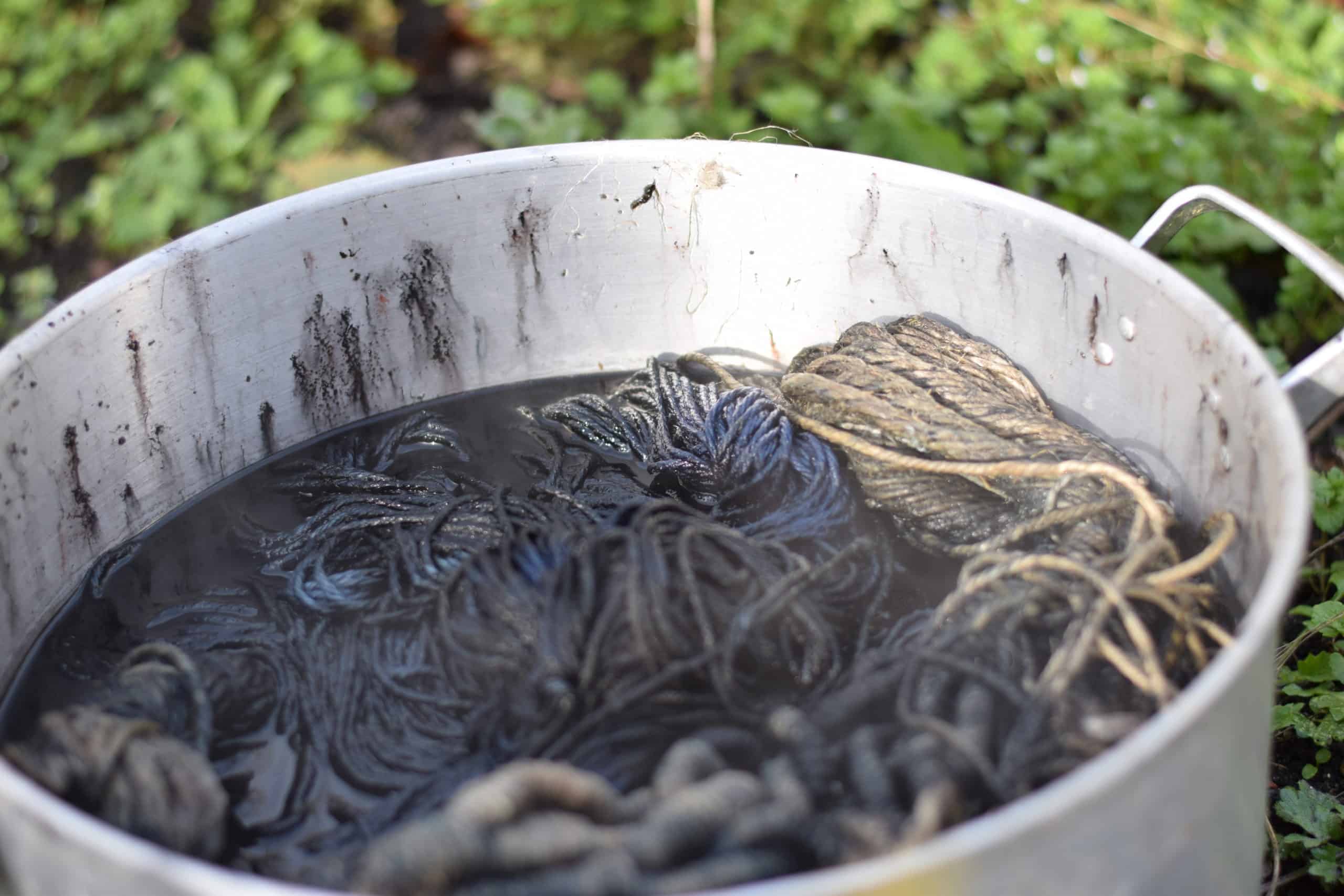Picture of balls of linen string being dyed in a metalic cauldron