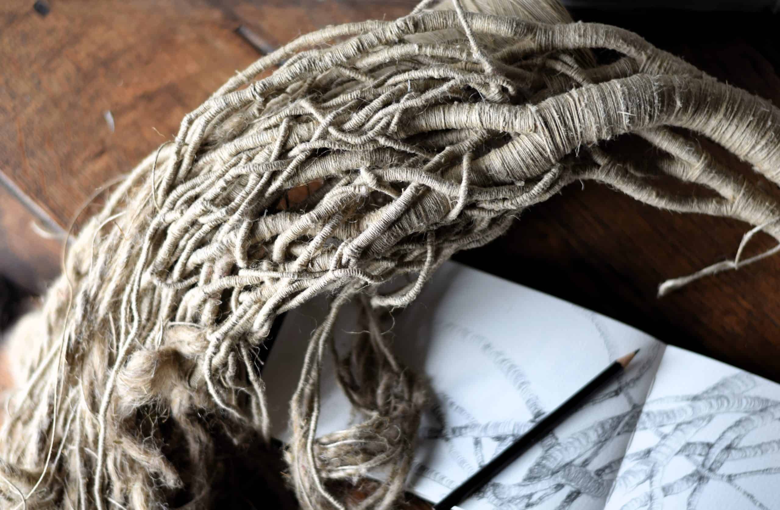 Unfinished sculpture by Aude Franjou with open sketchbook and pencil