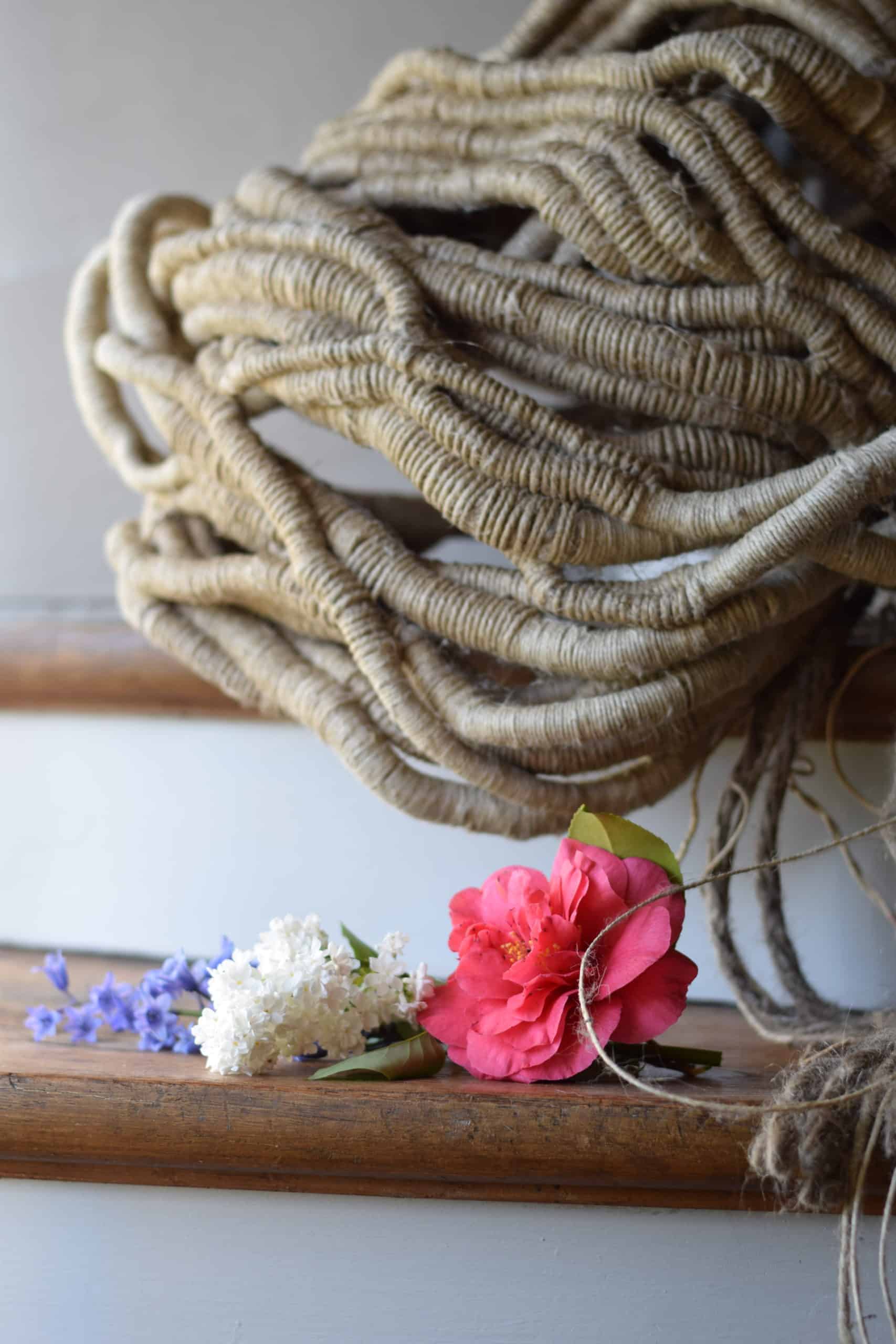 Picture of an undyed sculpture sitting on a shelf next to a few cut flowers