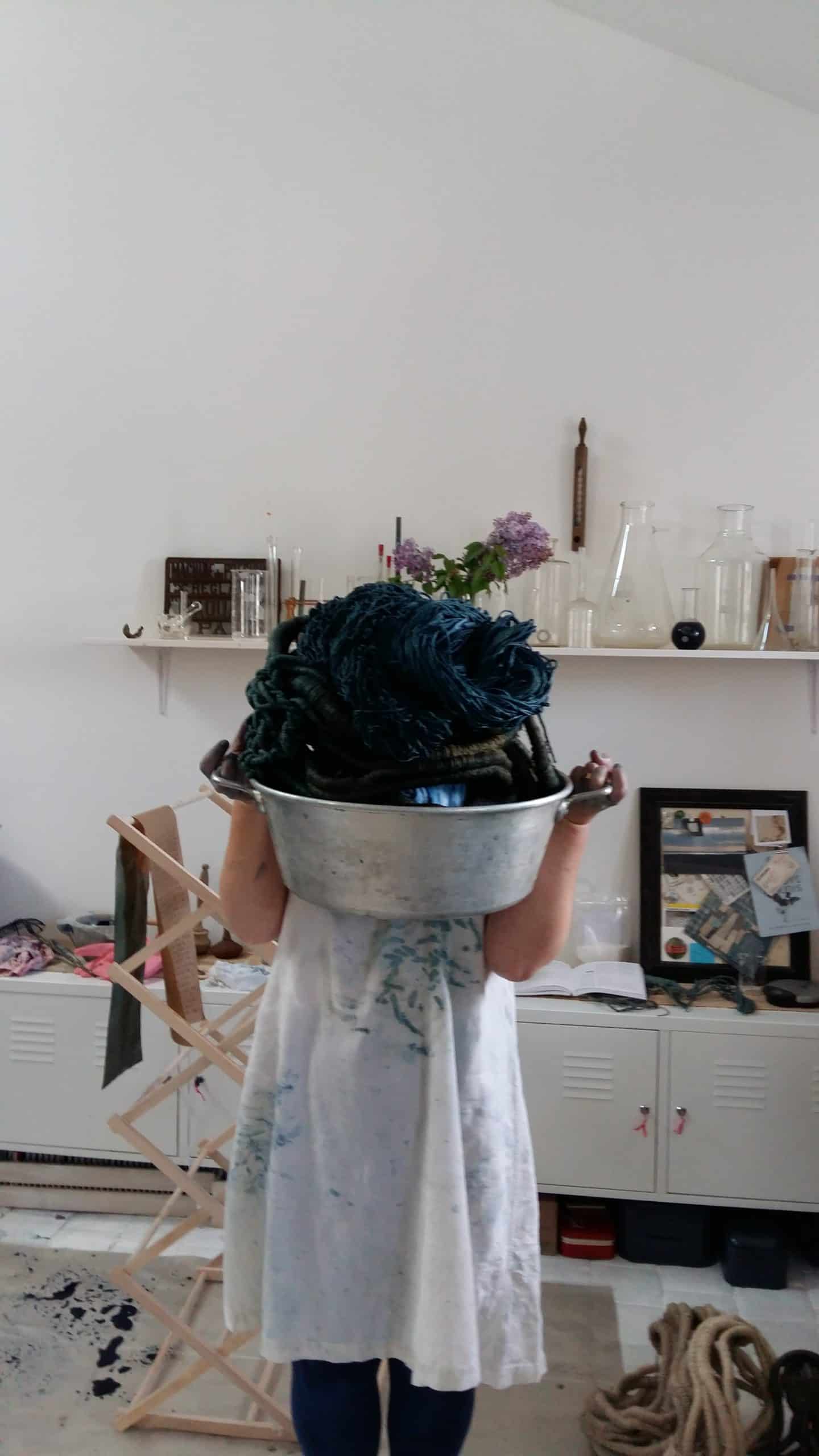 portrait of artist Aude Franjou hiding her face behind sculpting raw materials
