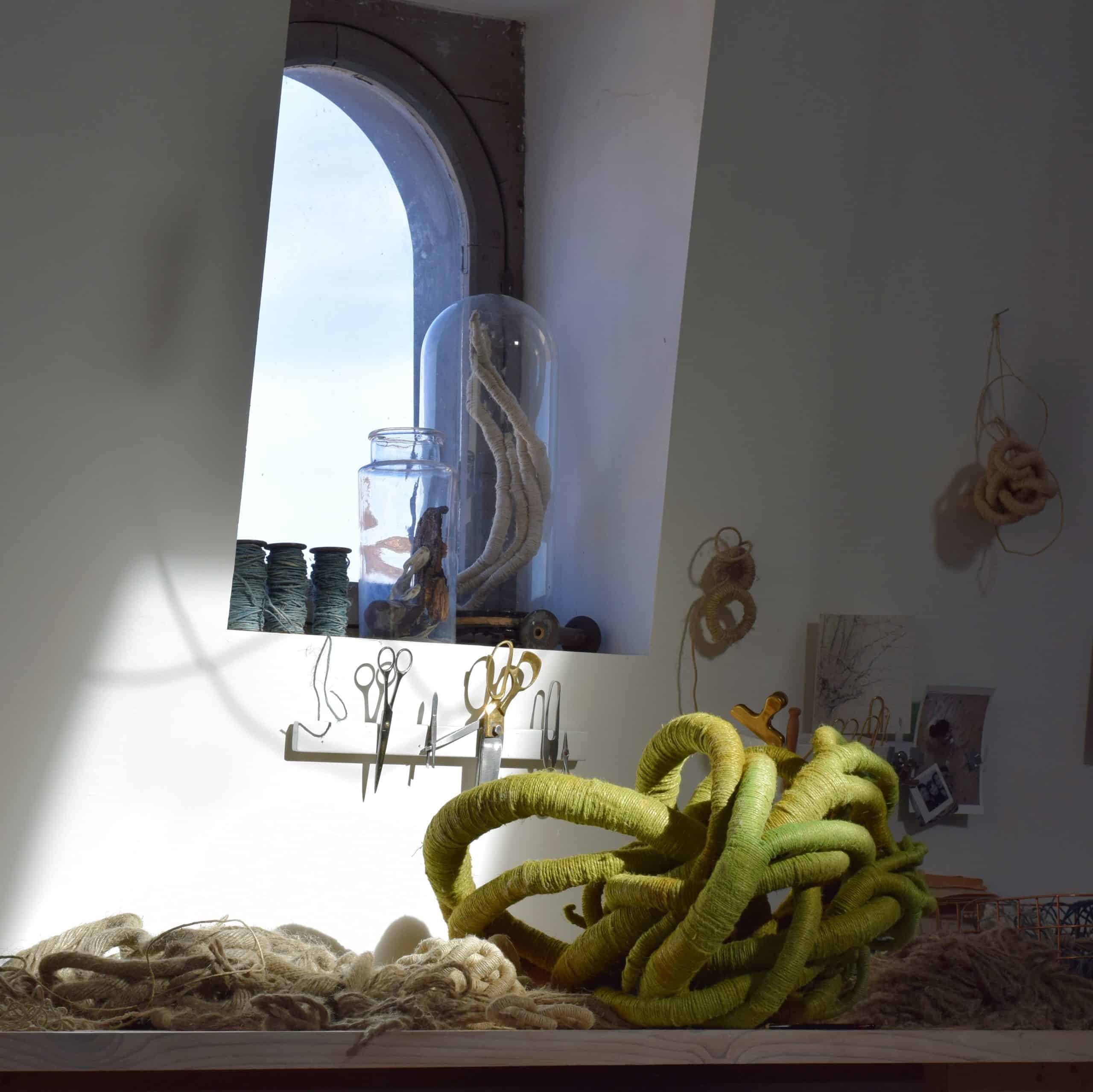 A green sculpture sitting in the sun in sculptor Aude Franjou's workshop