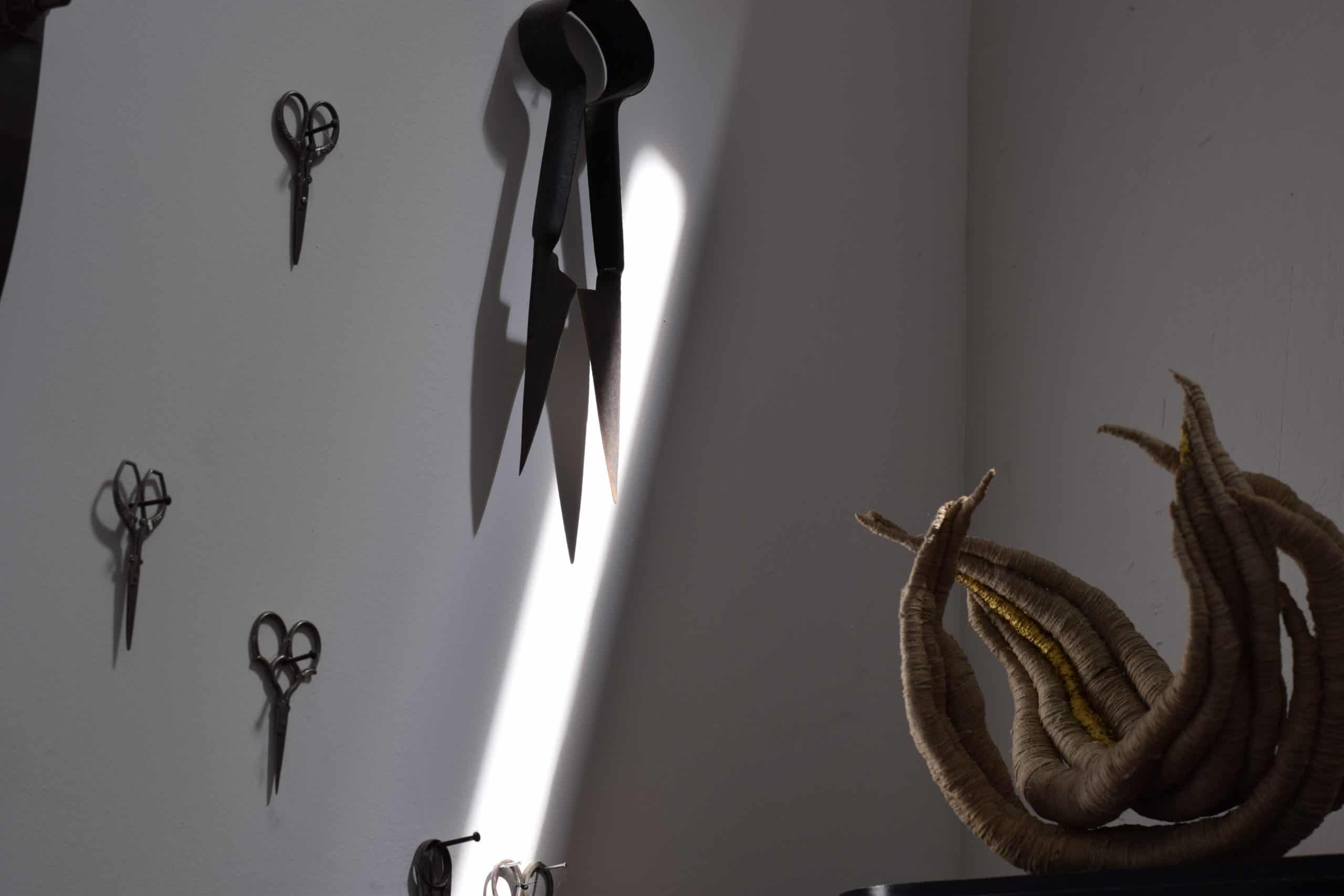 undyed and gold sculpture by Aude Franjou collection of scissors on a wall